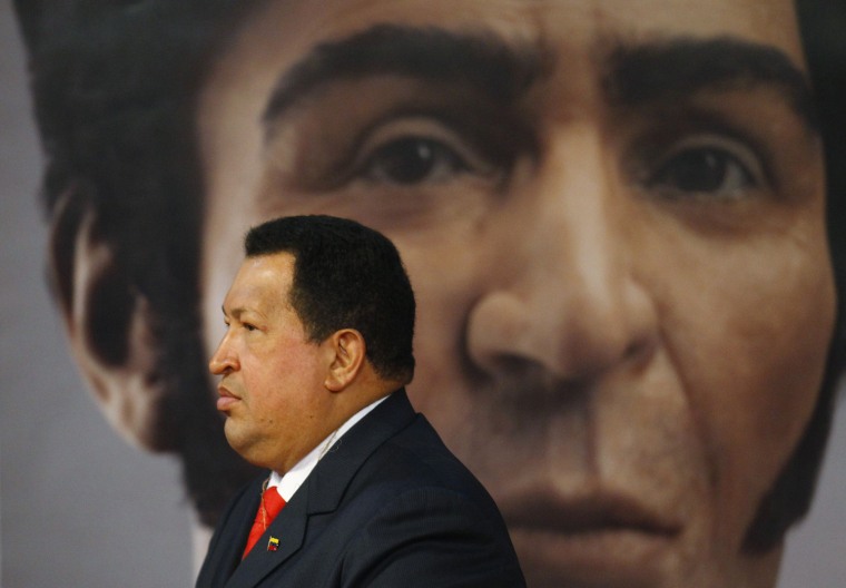 Image: Venezuelan President Chavez walks past an image of independence hero Bolivar during a ceremony in Caracas